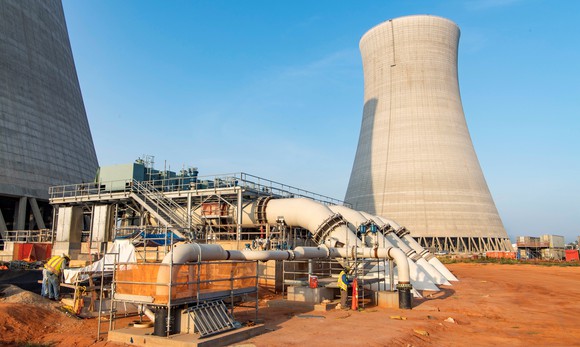 Nuclear cooling tower under construction against blue sky