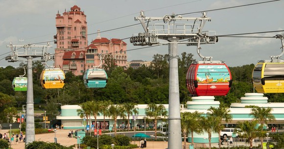 Disney Skyliner system gliding along the system with Disney's Hollywood Studios in the background. 