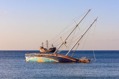 A sinking ship with an afloat ship behind it