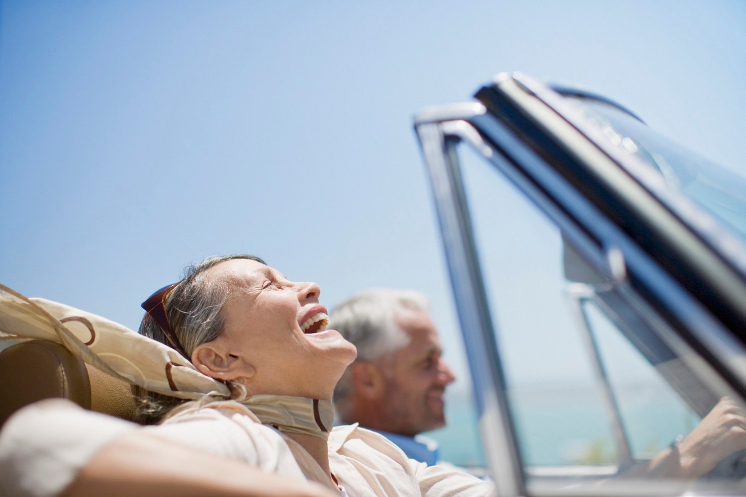 Retired man and woman in convertible.