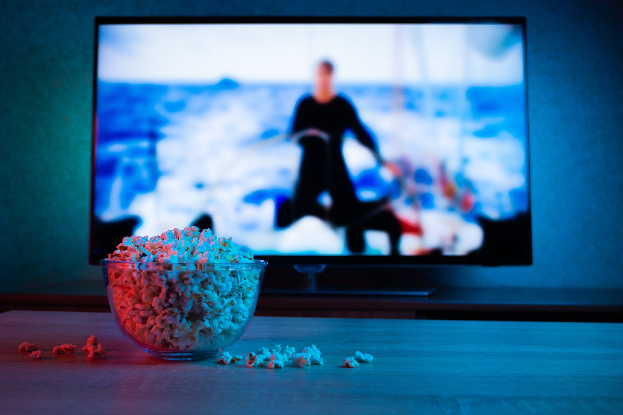 A bowl of popcorn in front of a TV