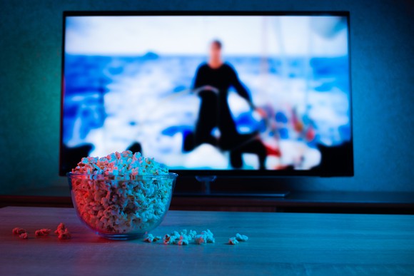 A bowl of popcorn in front of a TV