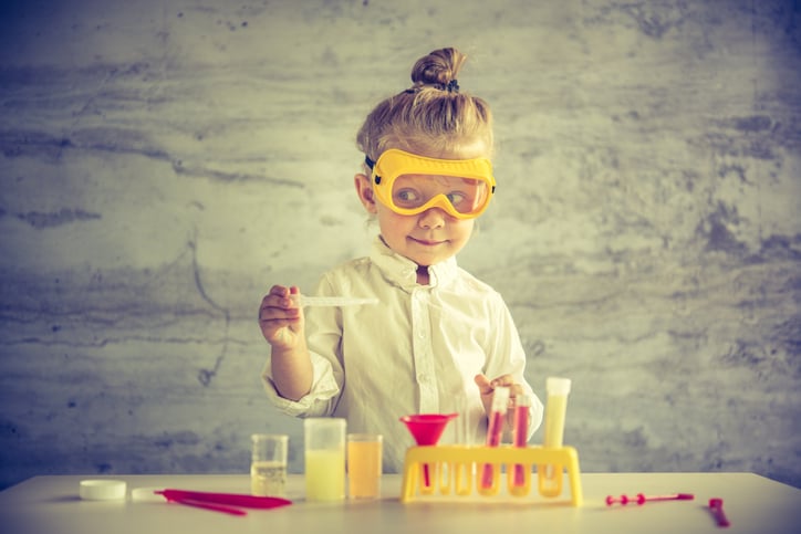 A little girl playing with a science kit.