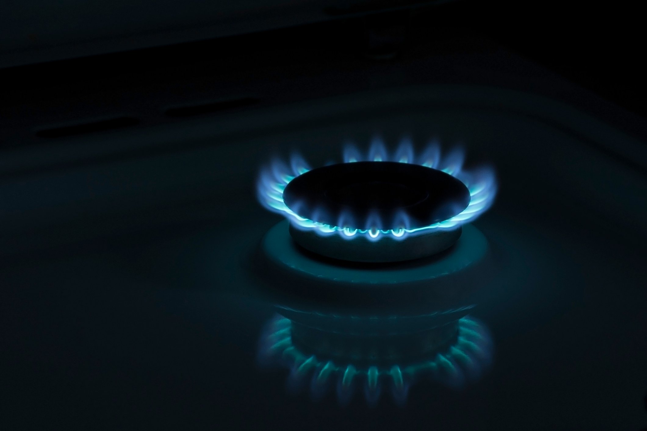 Blue flames rise from a gas burner.