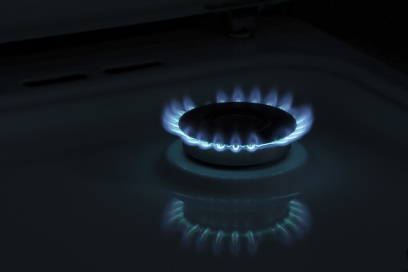 Blue flames rise from a gas burner.
