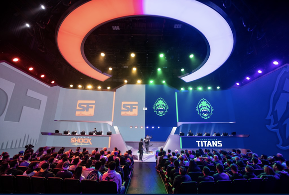 A brightly lit stage at Blizzard arena with a crowd of people waiting for a match to begin.