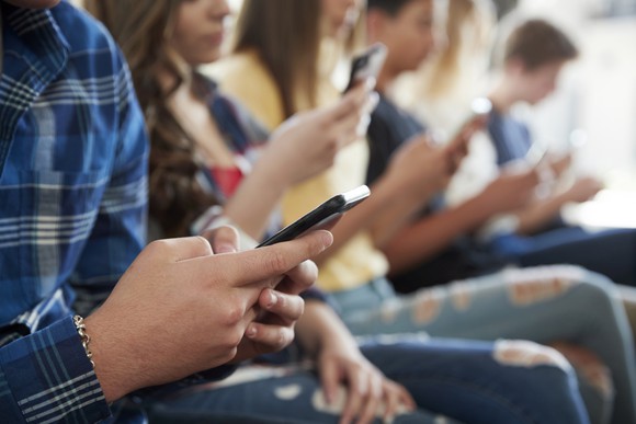 Teenagers using mobile device apps