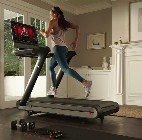 Woman running on a Peloton treadmill