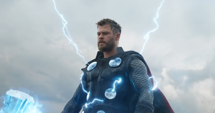 Thor stands holding his Stormbreaker axe with lighting emanating from his body. 