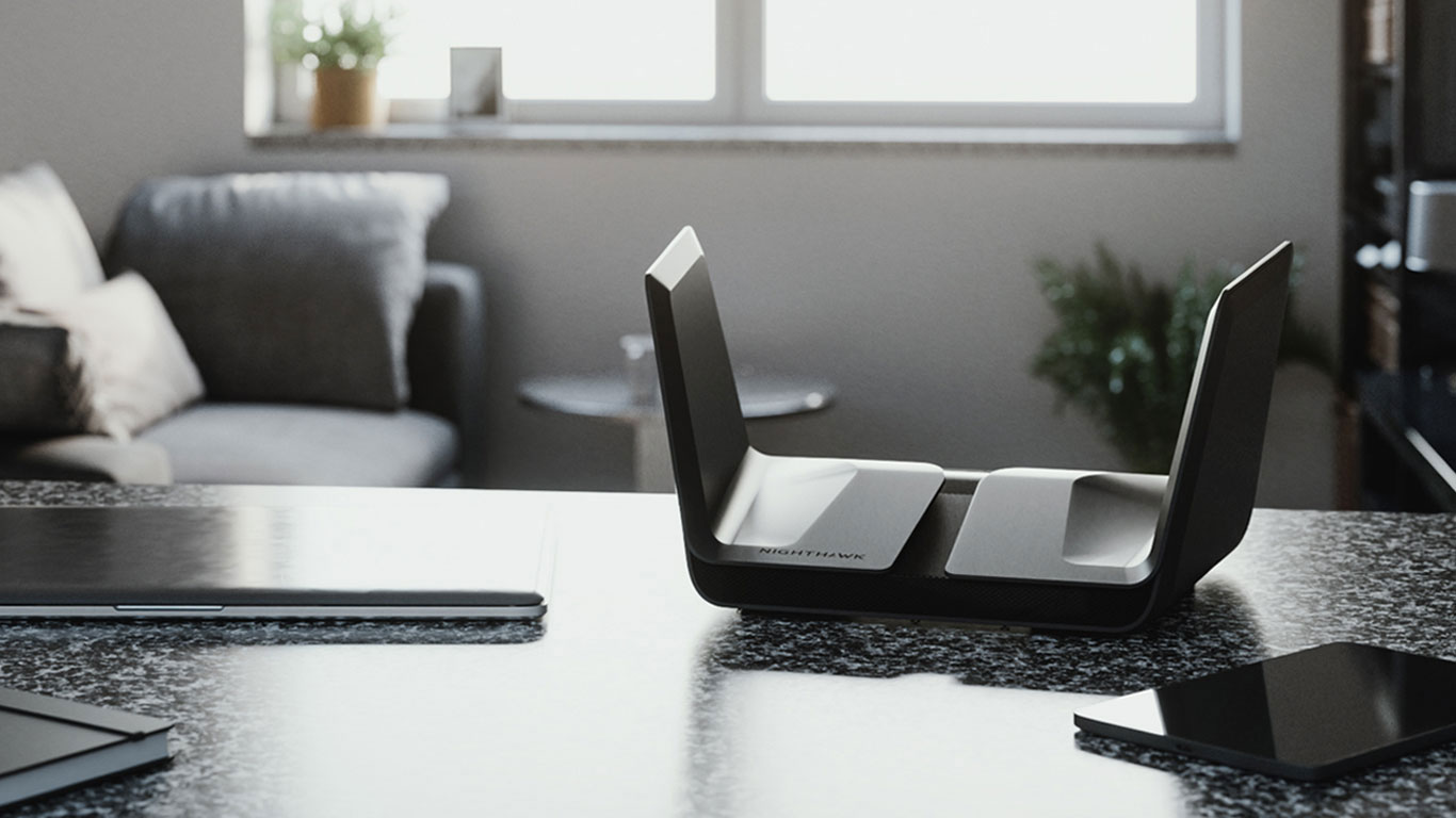 A TIE-fighter-shaped Netgear Nighthawk router sitting on a countertop in a home or office.