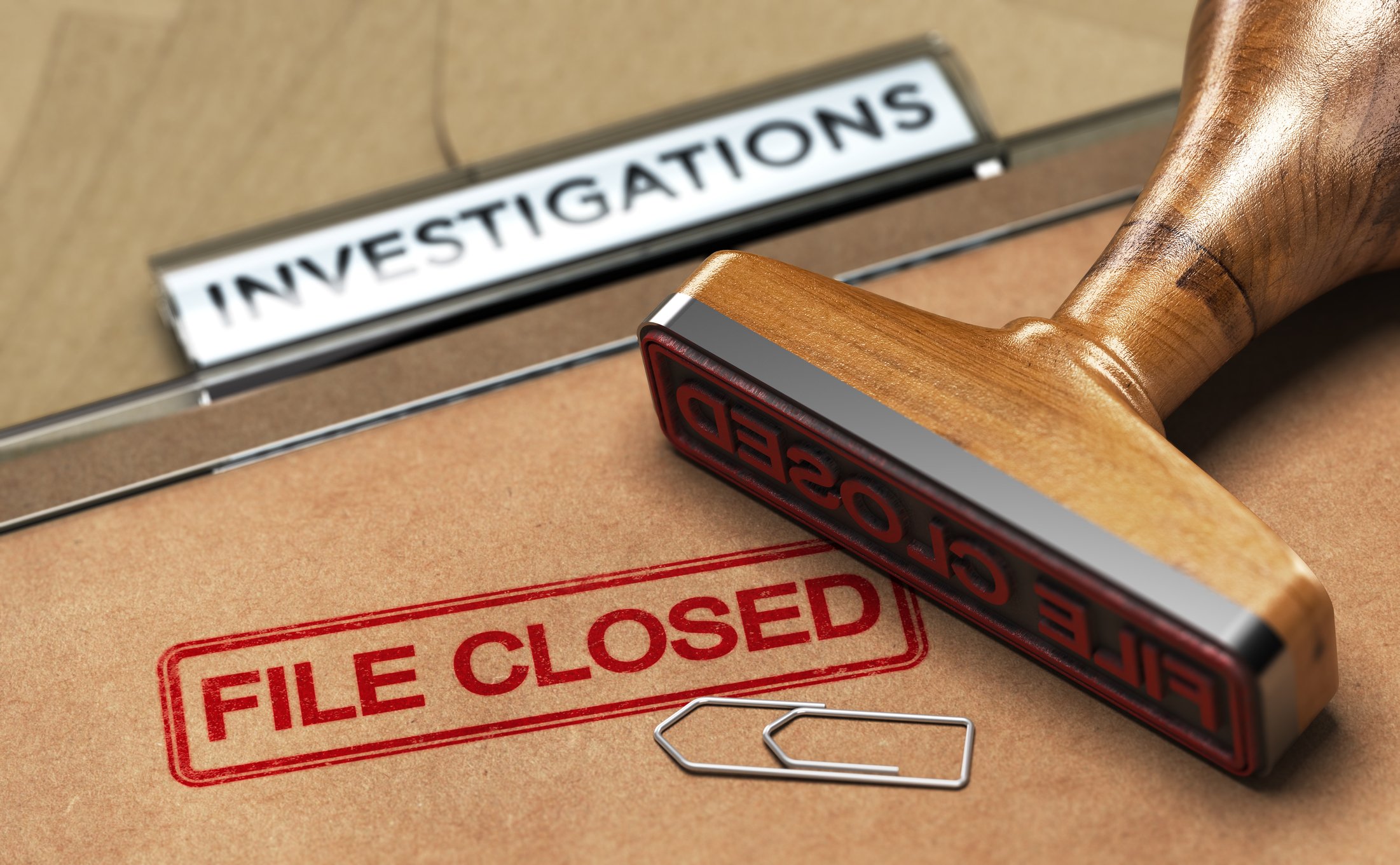 A folder with "File Closed" stamped on it next to an "Investigations" sign
