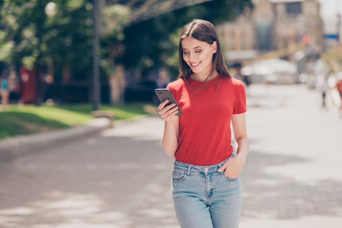 Girl using her phone and smiling.