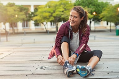 woman athlete lacing up running shoes