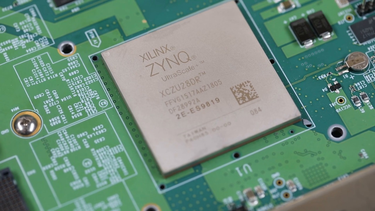 A Xilinx Zynq chip displayed on a green circuit board.