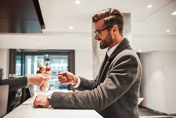 A businessman checks into a hotel in a contemporary hotel lobby.