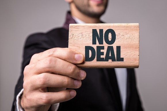 Businessman holding wood block with "No Deal" printed on it