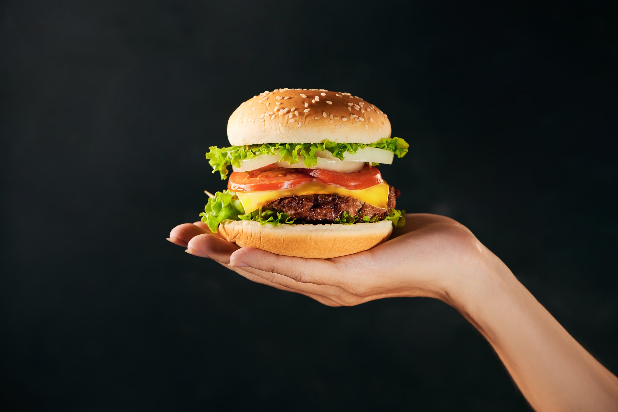 A burger in the palm of someone's hand