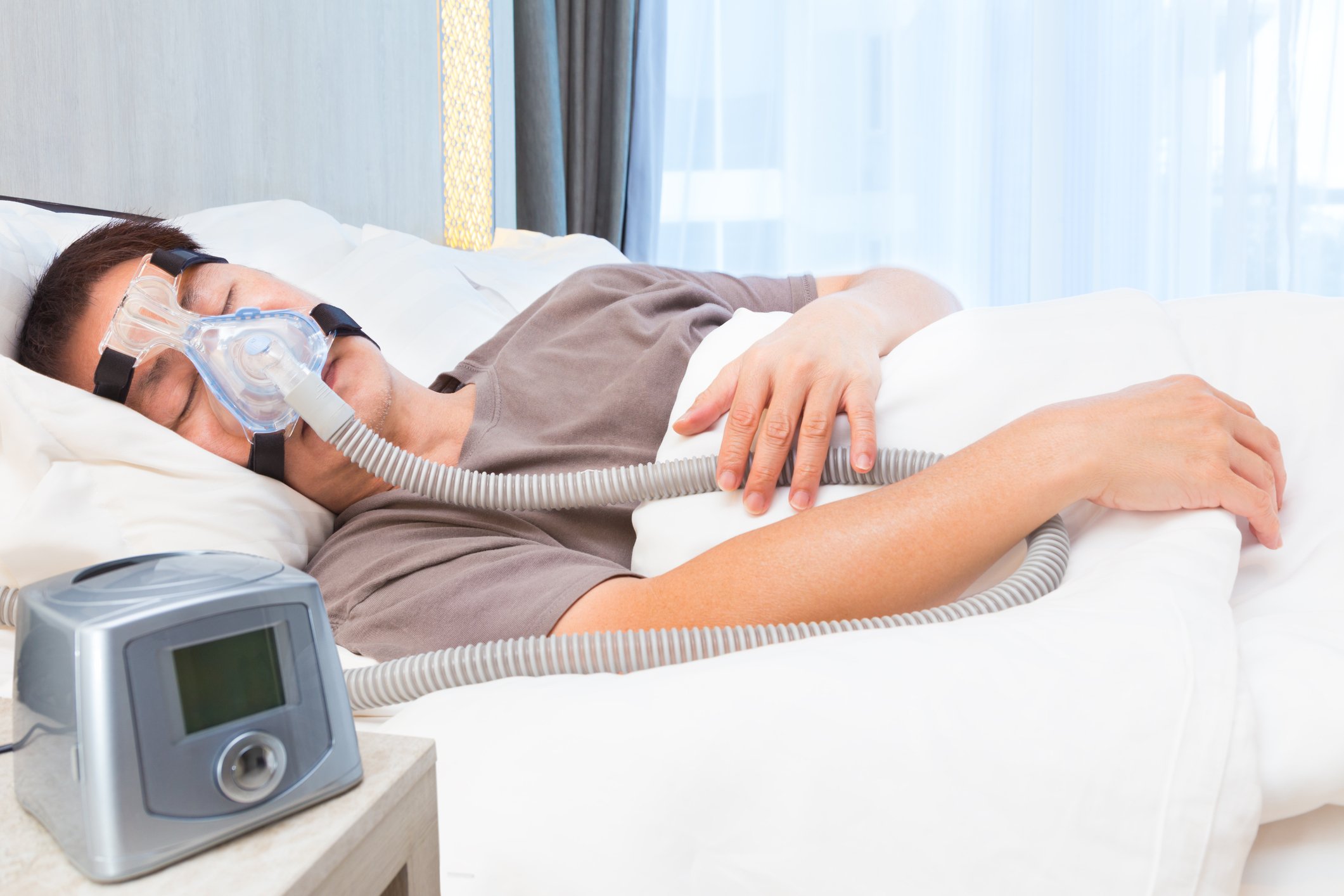 Man sleeping with CPAP machine on face.