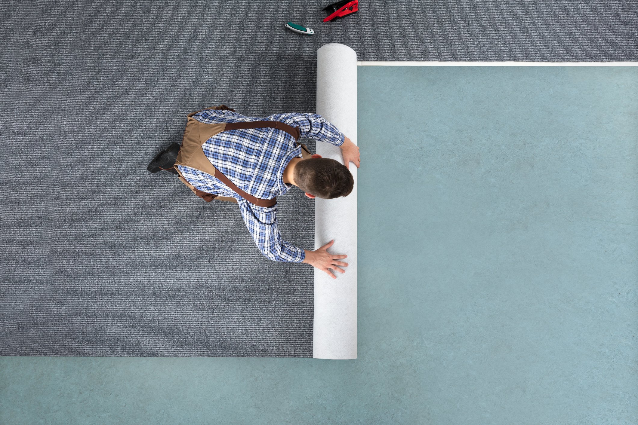 Man installing carpet on floor