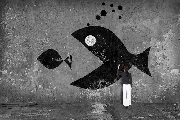 A person drawing a picture of a big fish eating a smaller fish.