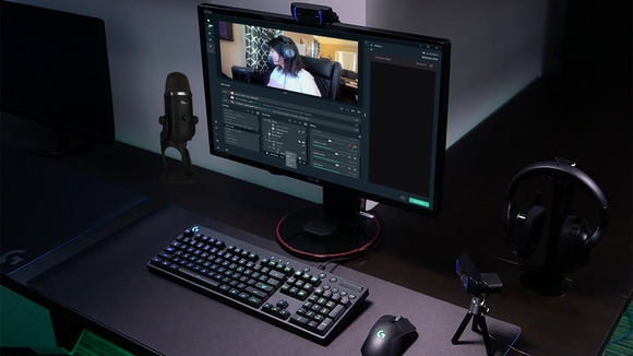 A computer monitor, with Logitech keyboard, mice, and other peripherals set up on a desk with software by Streamlabs showing a live streaming broadcast.