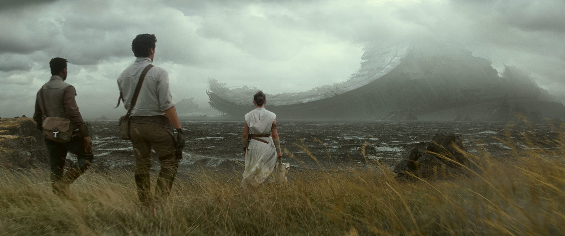 Rey, Finn, and Poe looking at remnants of a downed Death Star.