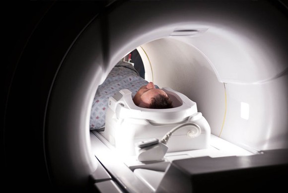 A patient being scanned by a GE-made CT Scanner.