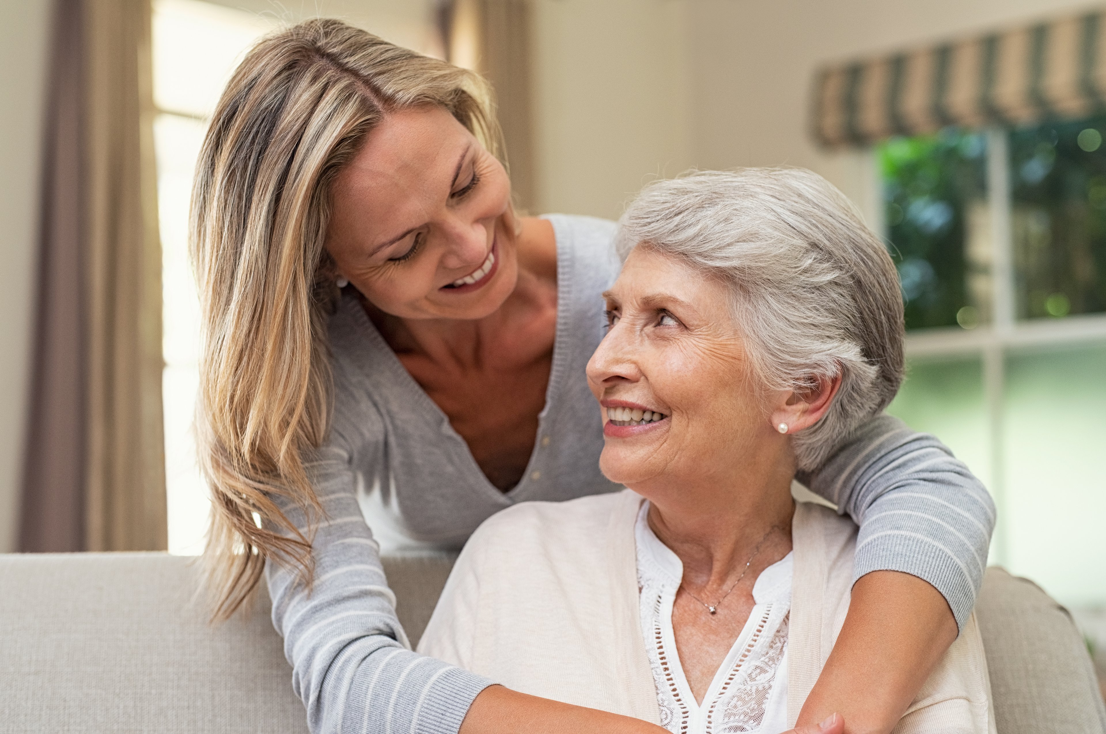 A woman hugs her aging mother