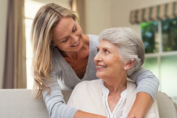 A woman hugs her aging mother
