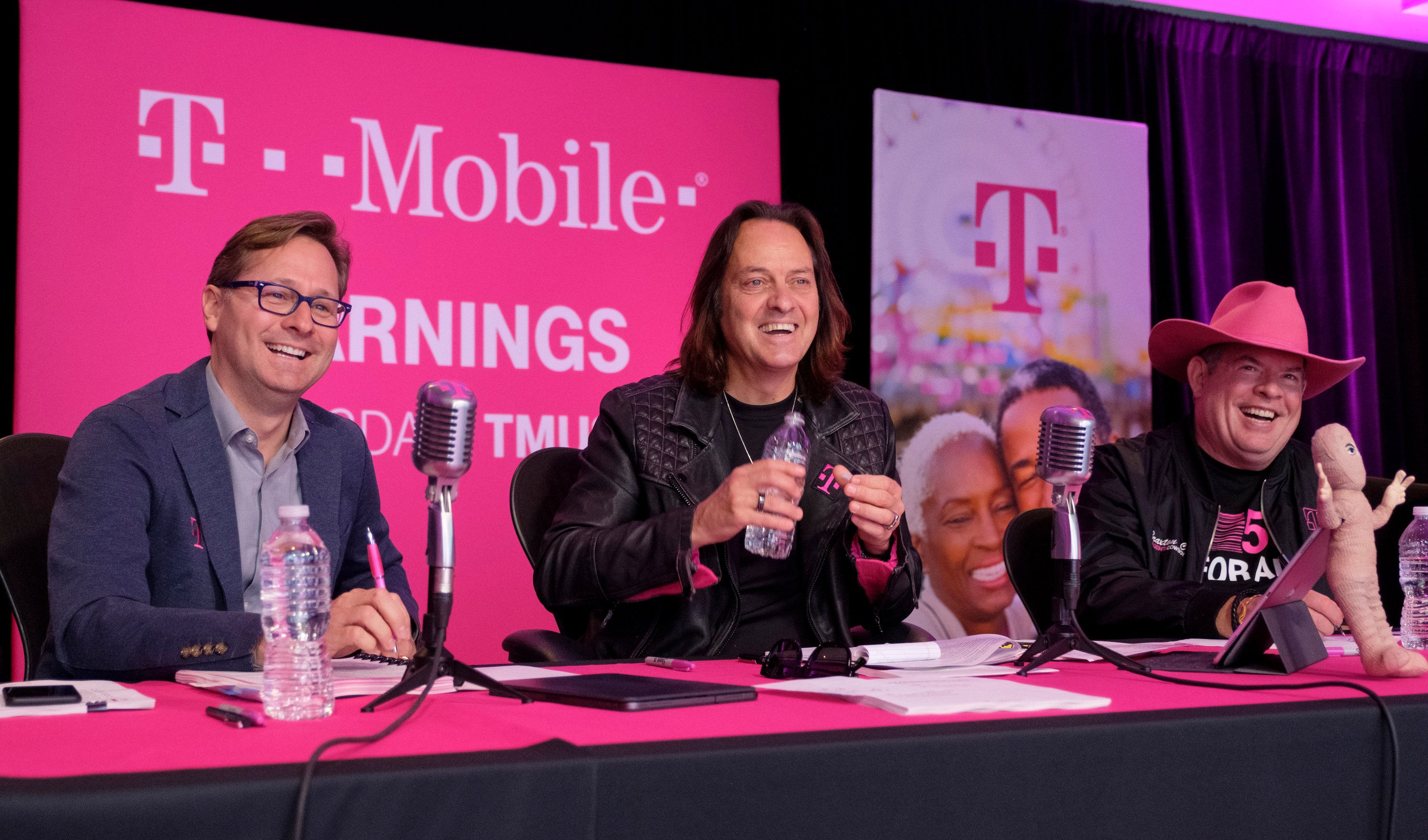 T-Mobile management seated at a table with microphones