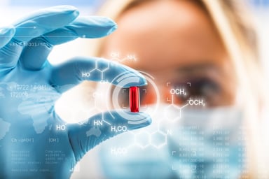lab worker holding up capsule
