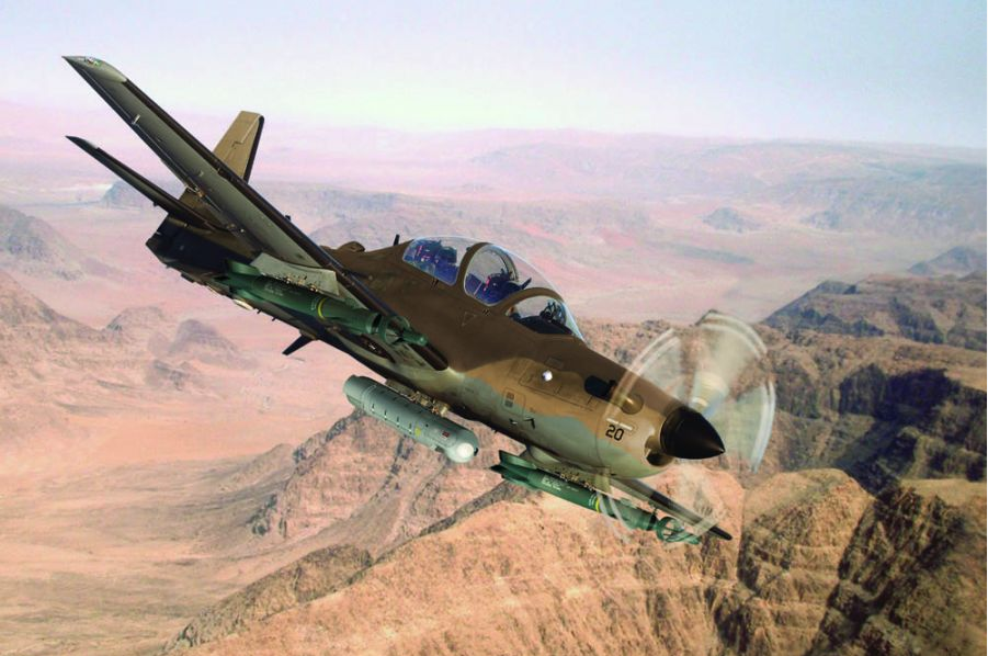 The A-29 in flight over a desert scene.