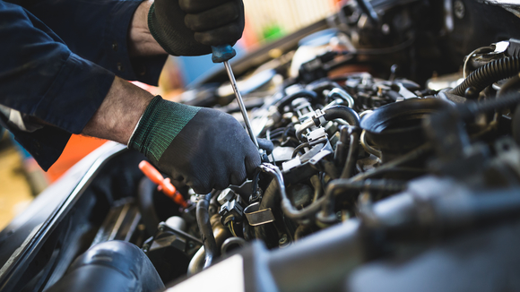 mechanic works on car engine