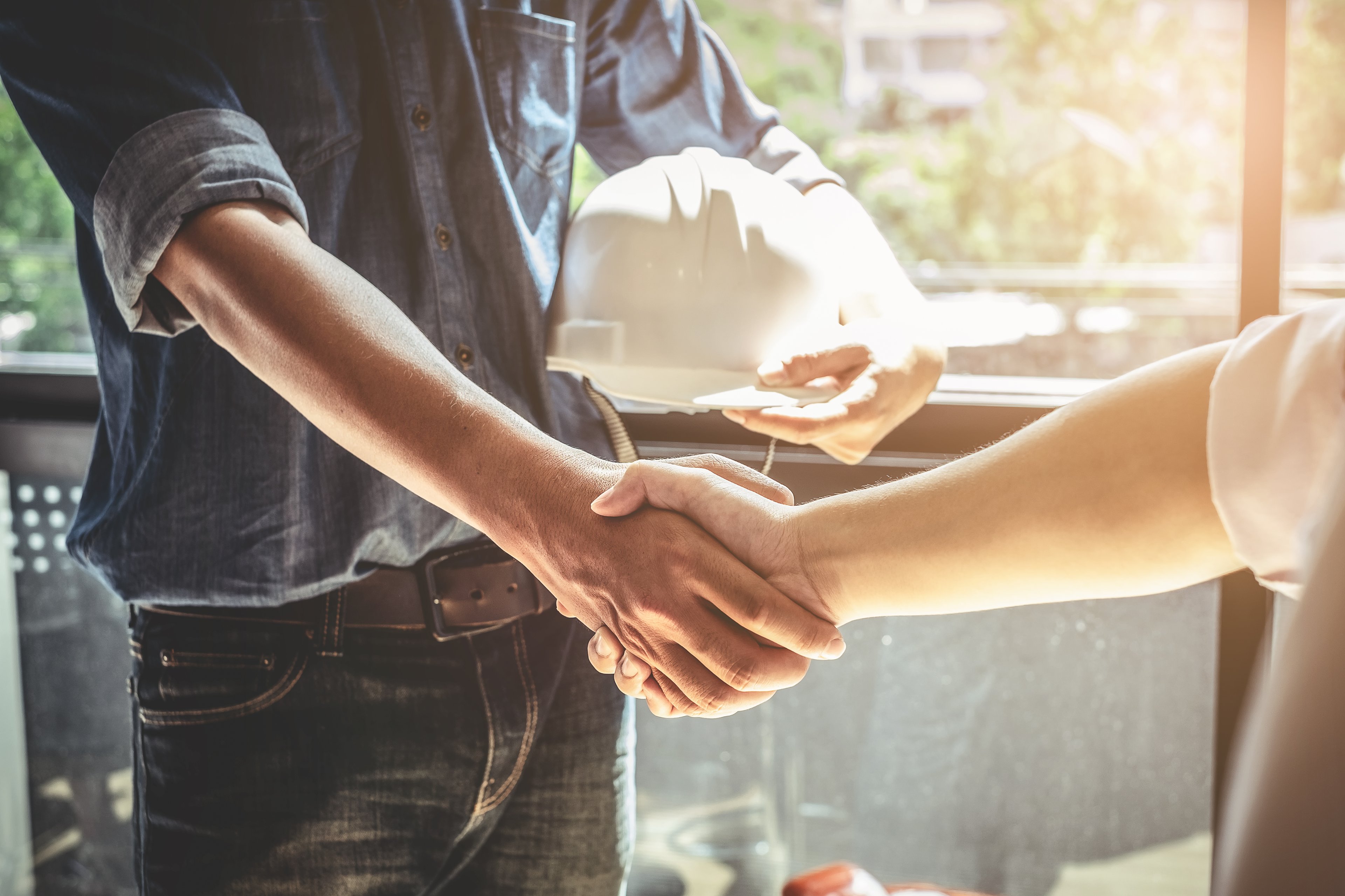 A person shaking the hand of a construction worker