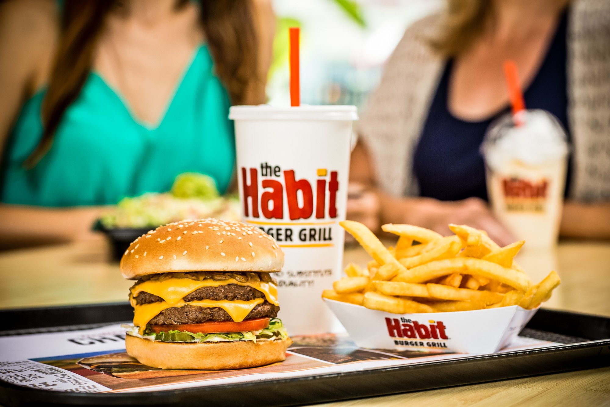 A meal including a burger, fries, and a drink from with the Habit logo on a tray