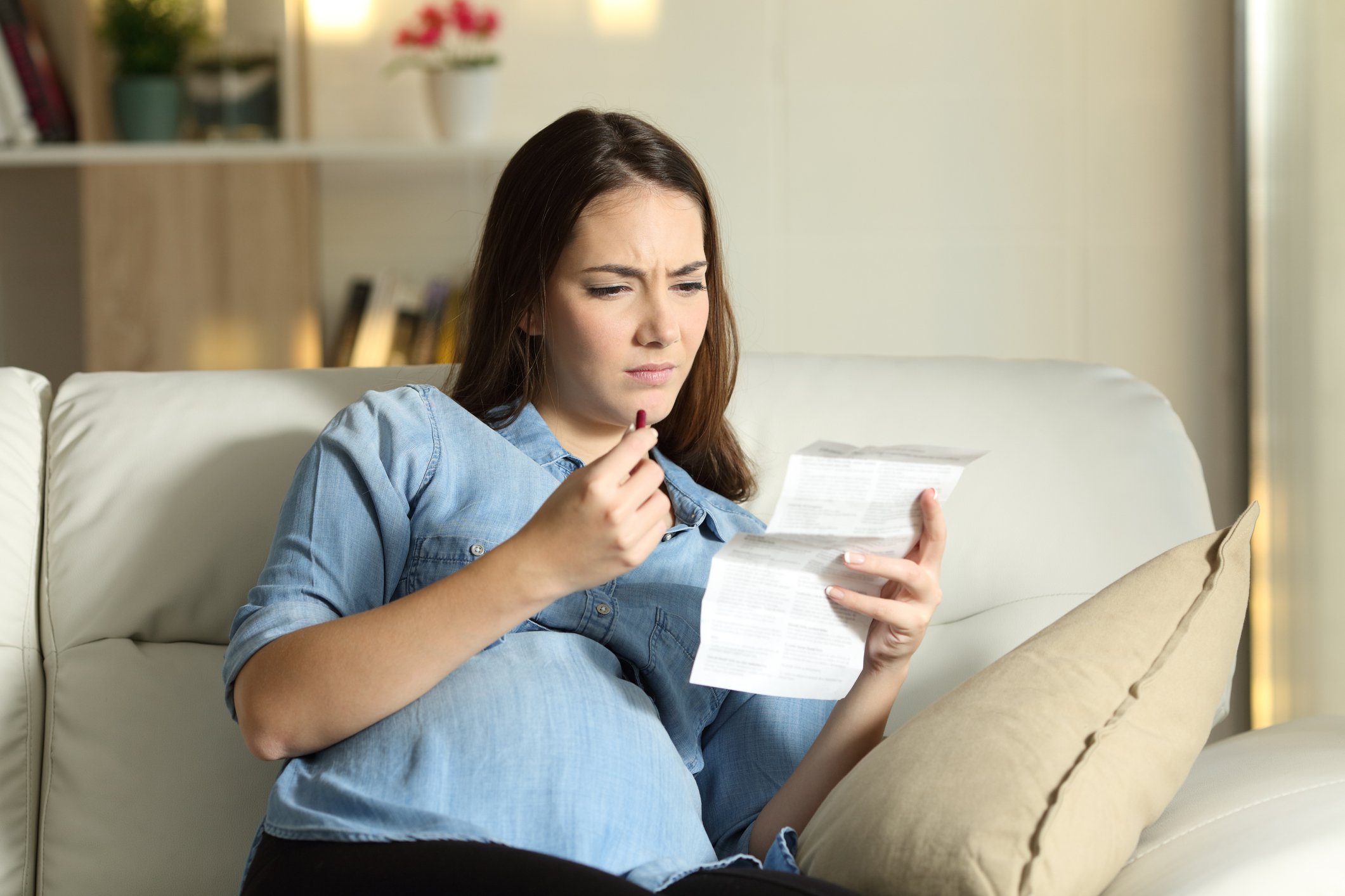 Woman reading a document and holding a red pill