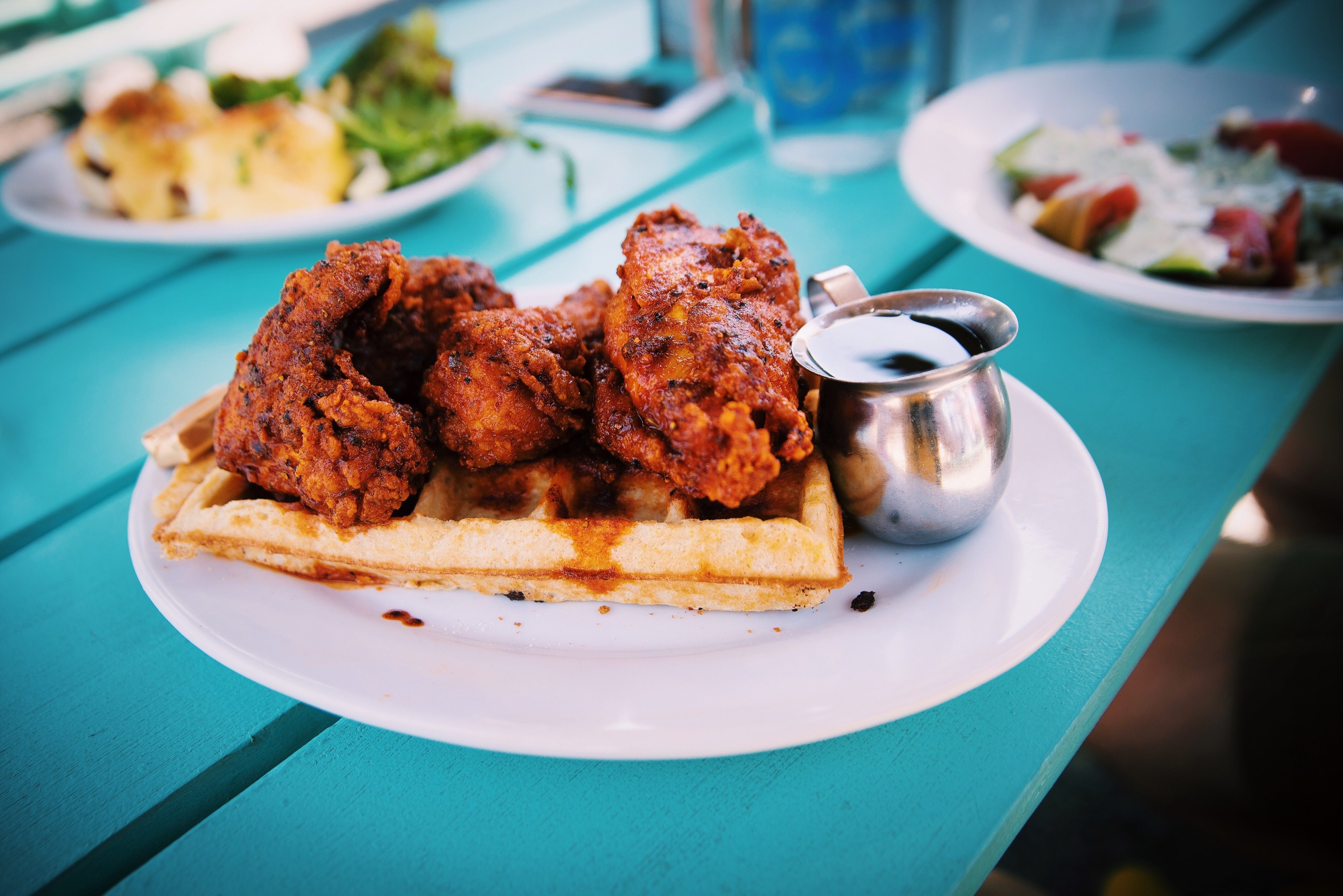 Fried chicken and waffles with a side of syrup 