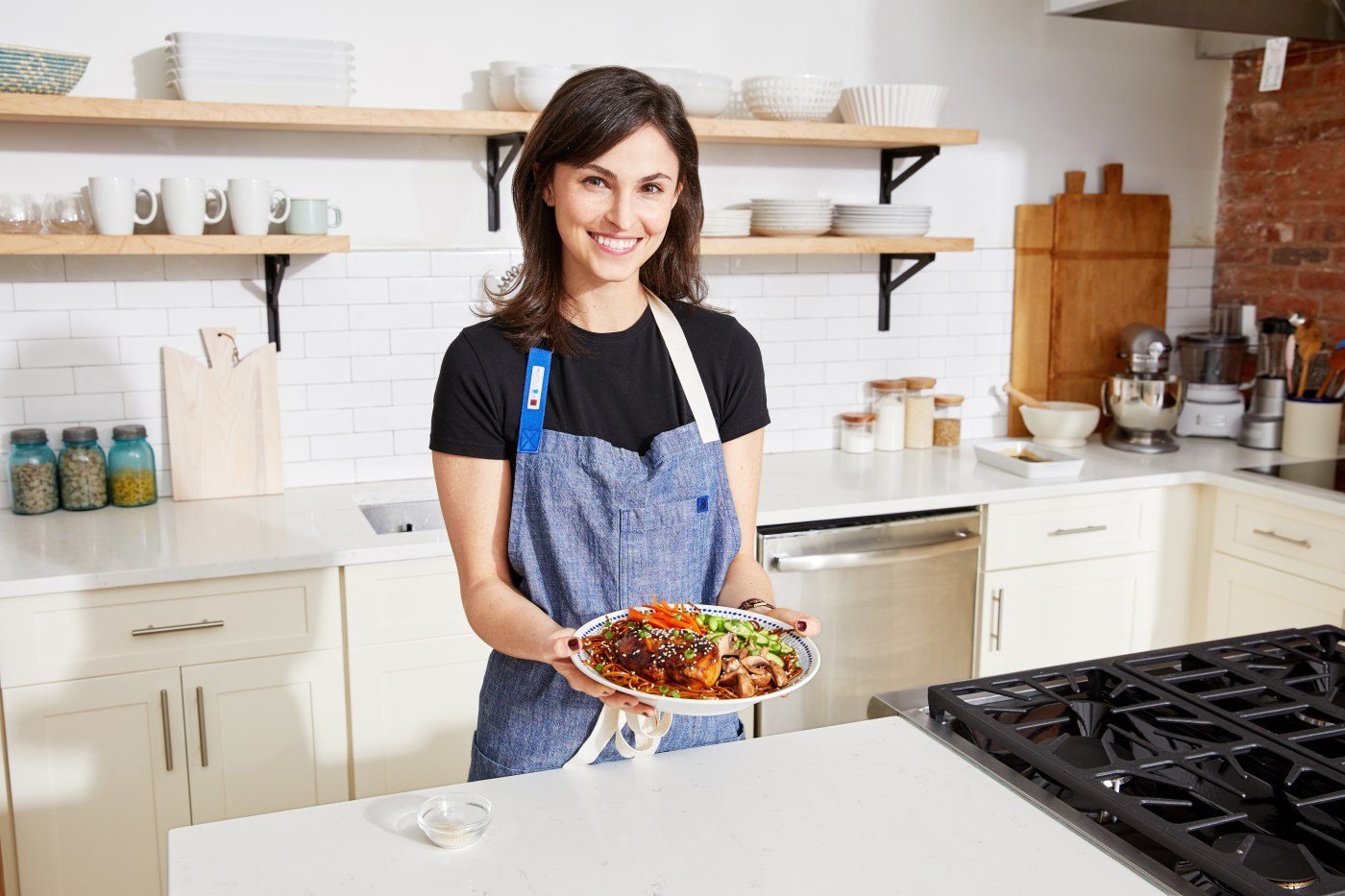 A chef holding a Blue Apron dish