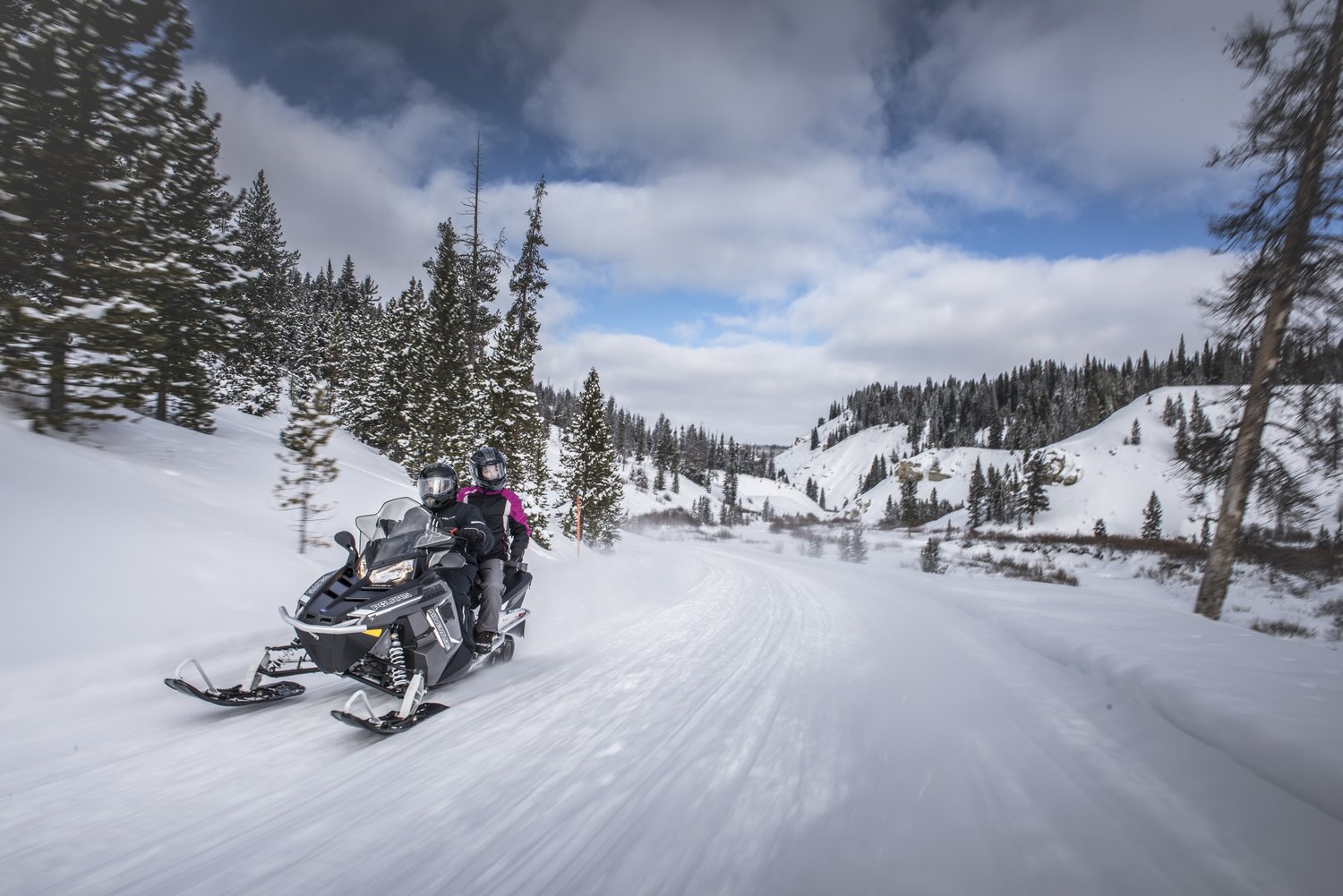 Two people on a Polaris snowmobile