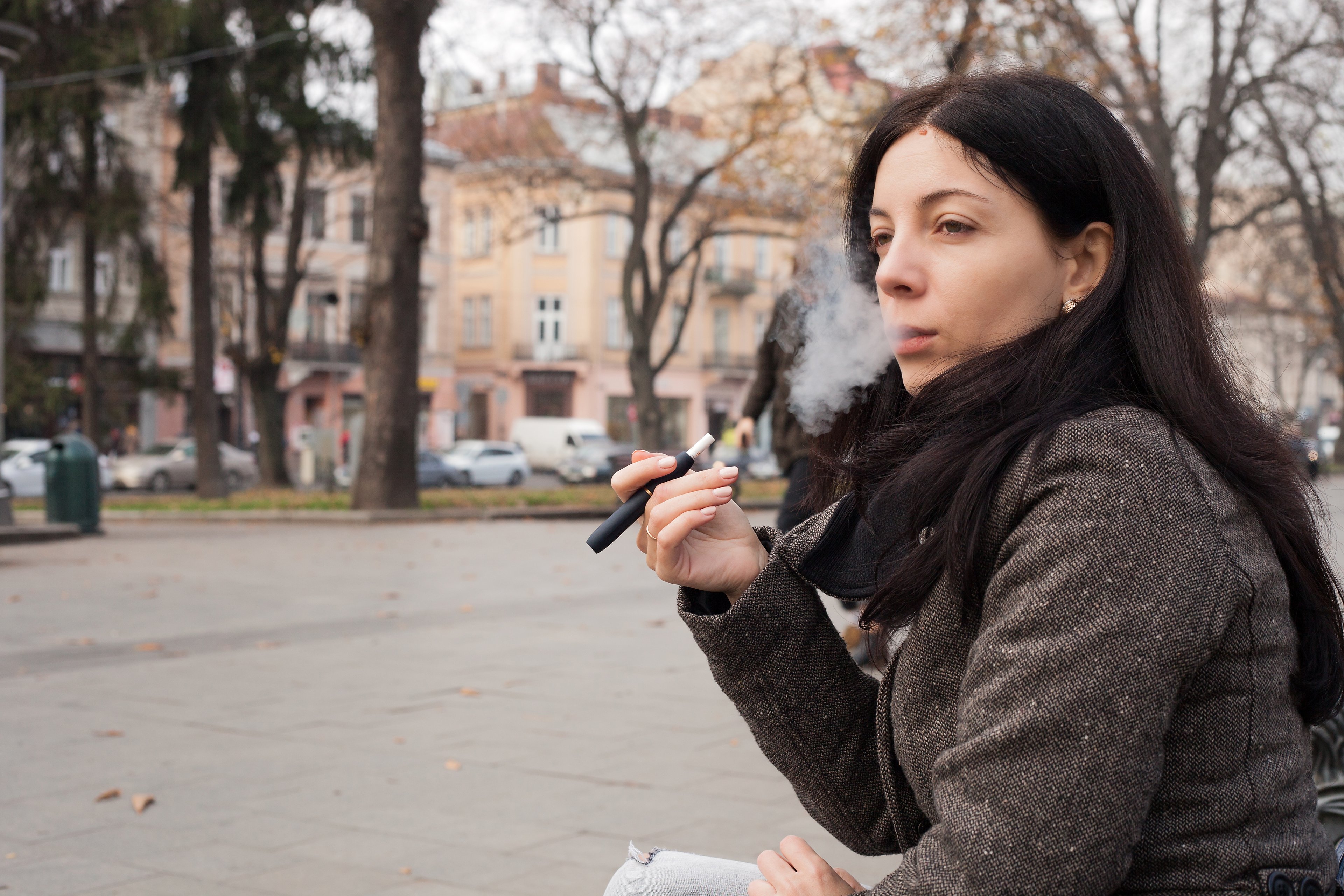 A woman smoking an IQOS system