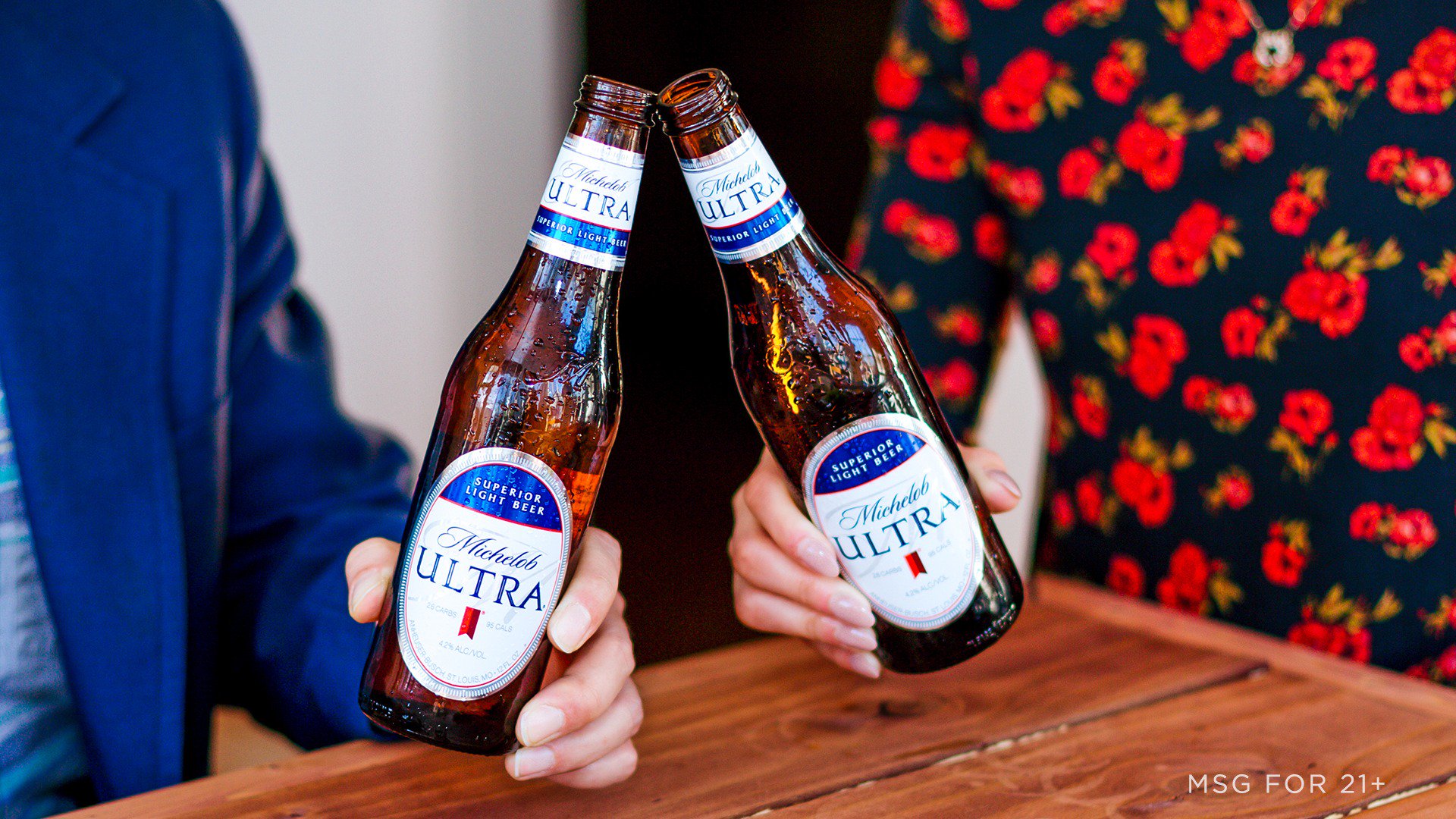 A man and woman toast bottles of Michelob Ultra.