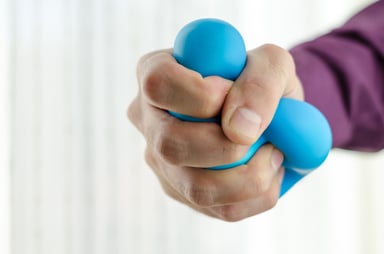 A hand squeezing a stress toy