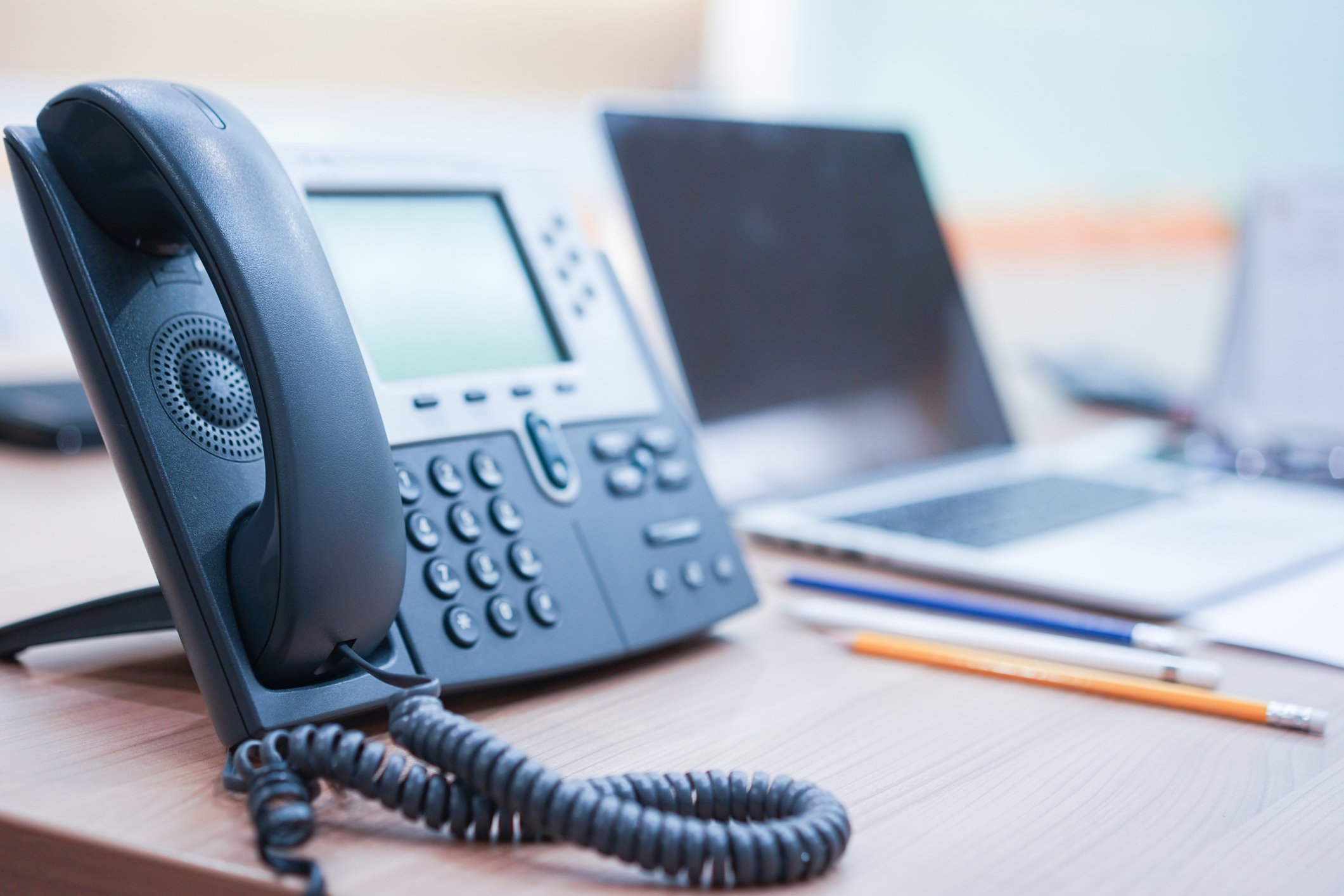 An office phone system sitting on a desk.