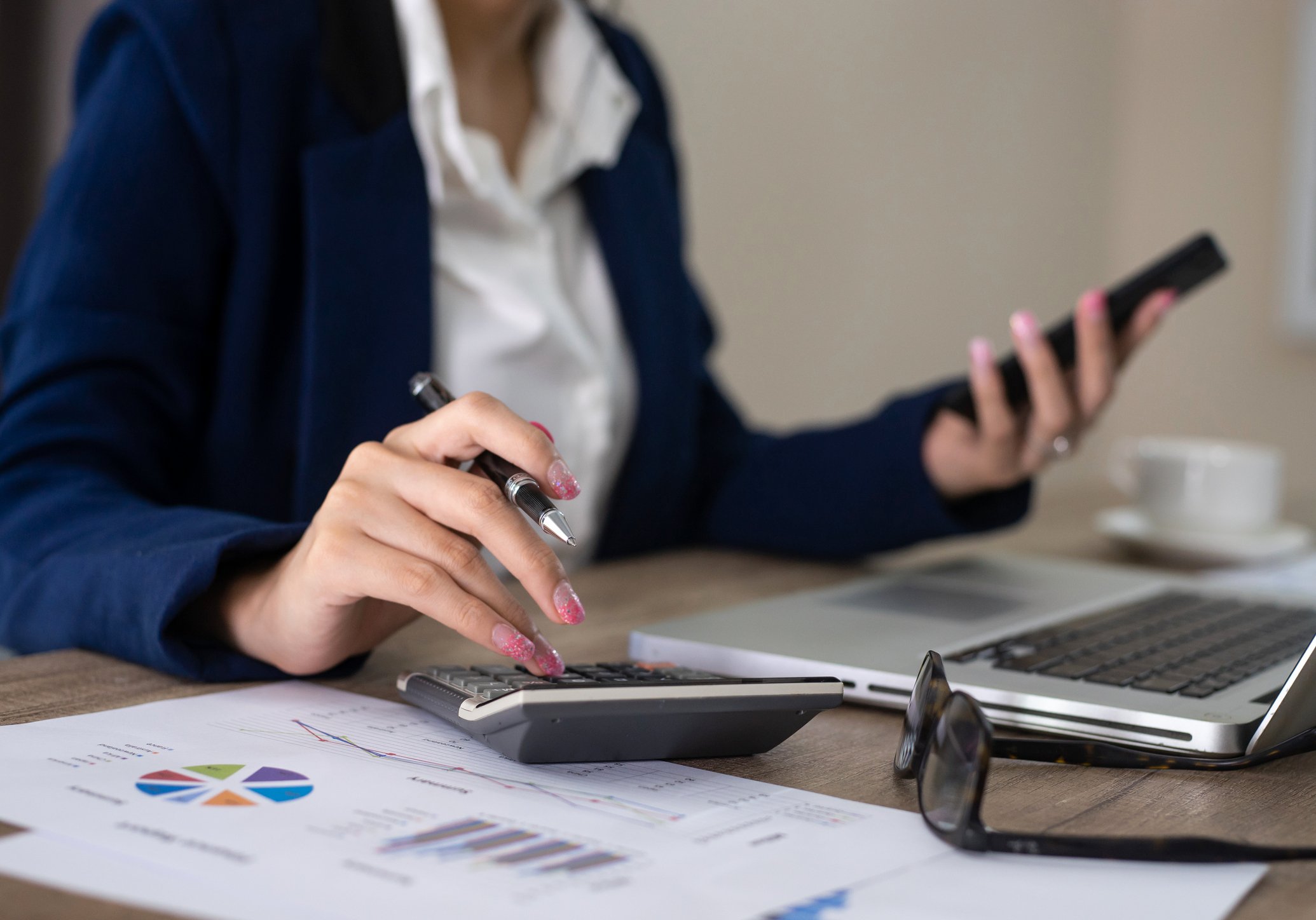 A banker does calculations at her desk.
