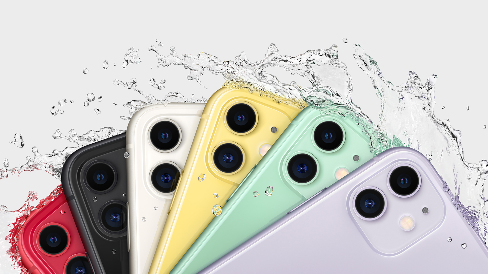 iPhones in several colors arranged in a fan and being splashed to illustrate water resistance.