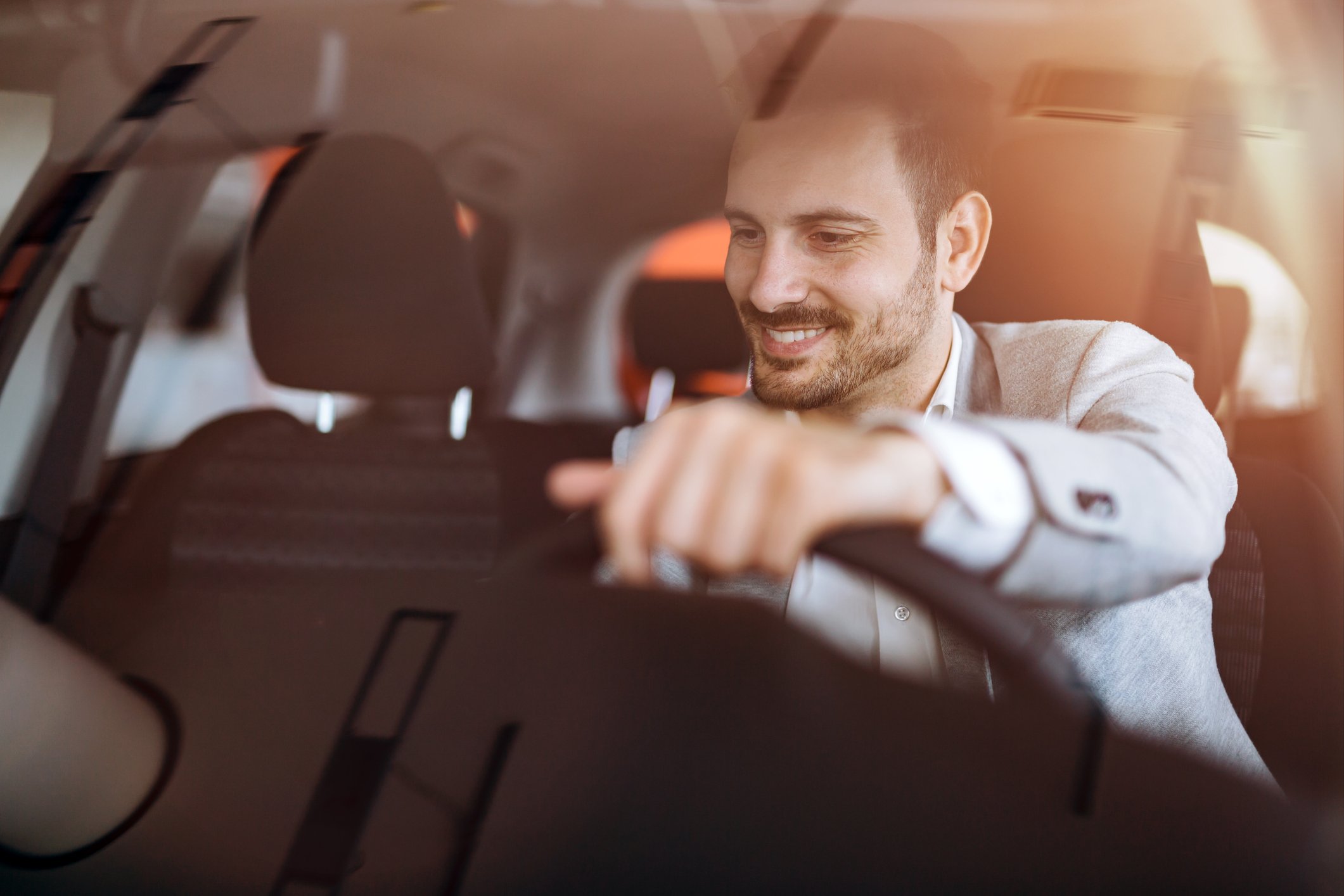 A man smiles behind the wheel of his new vehicle.