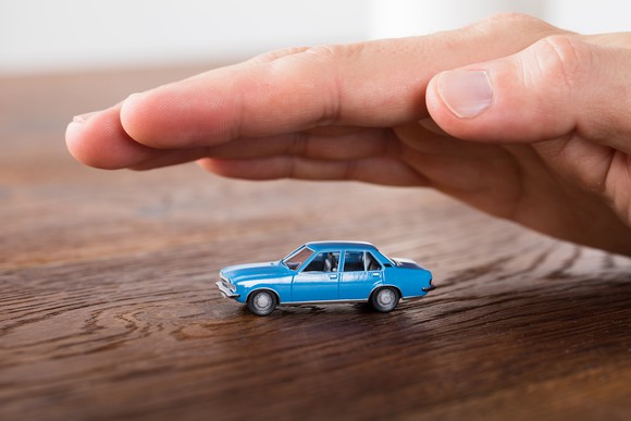 Hand hovering over a toy car.