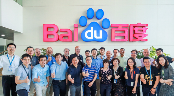 About two dozen Baidu researchers posing in front of the corporate office logo.