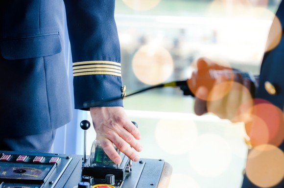 Close-up of a cruise ship captain at the controls of a modern vessel.