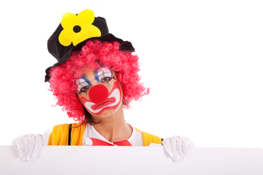 Sad clown looking over a wall